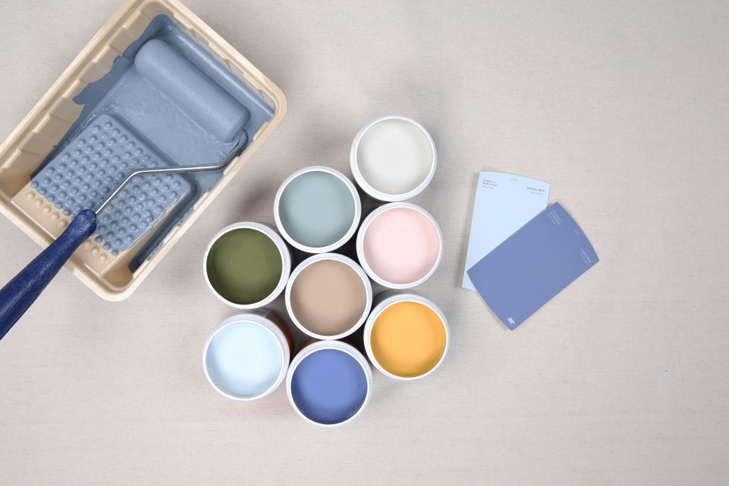 Image showing eight 8oz paint samples, two color chips and a painting tray with a painting roller. 