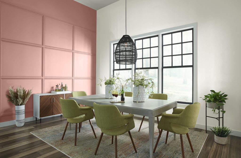 A dining room with one creamy white wall and the other wall as a muted peach.