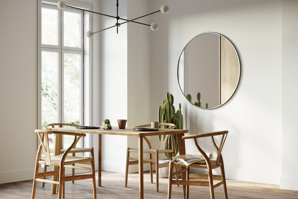 Dining room interior with wooden chairs and table and mirror on the wall. The color on the wall is Whipped Cream.