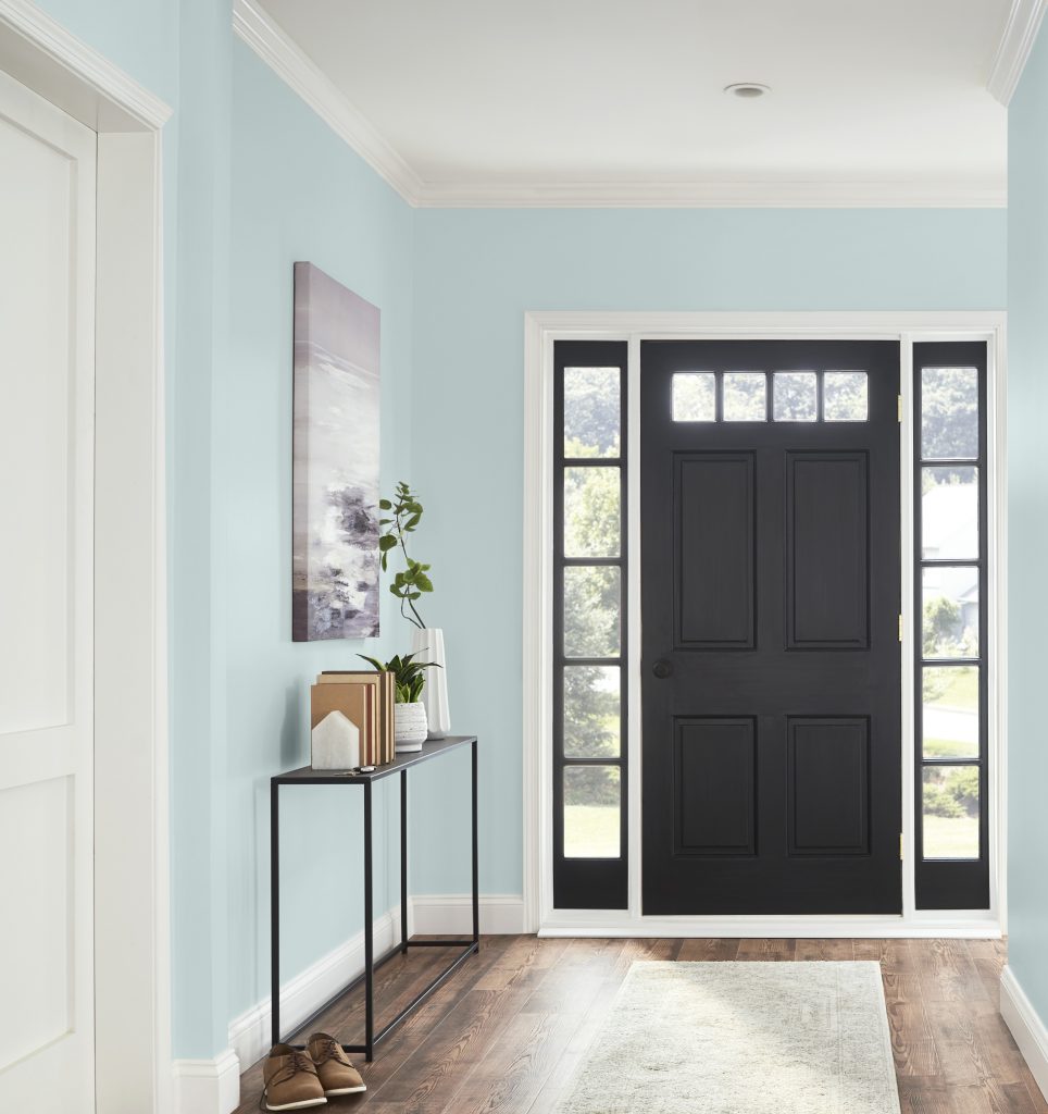 An entryway with blue walls and black front door.  