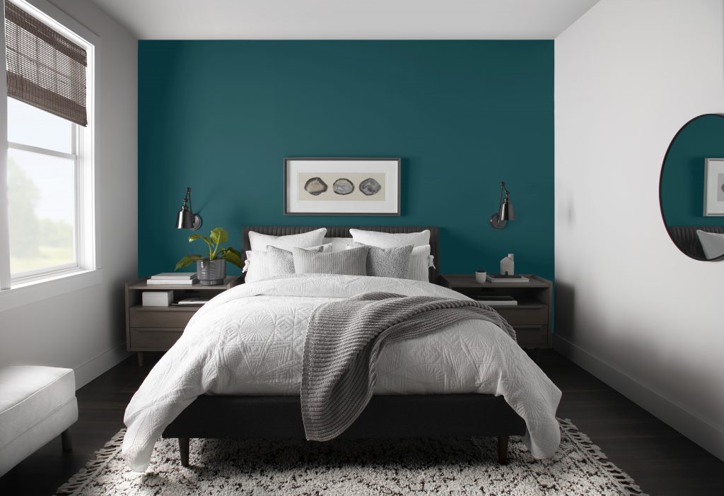 A bedroom with the wall painted in a deep blue color.