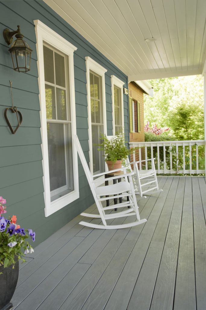 The porch of an exterior home painted in a dusty green.