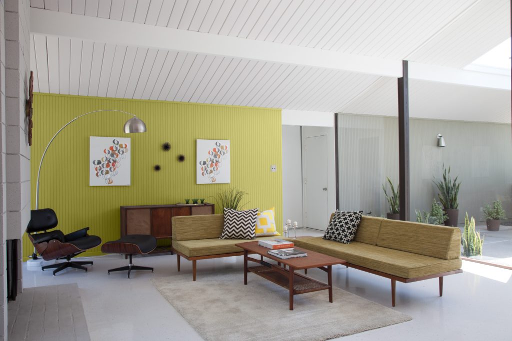 A sunroom with one wall painted in a bright green color.