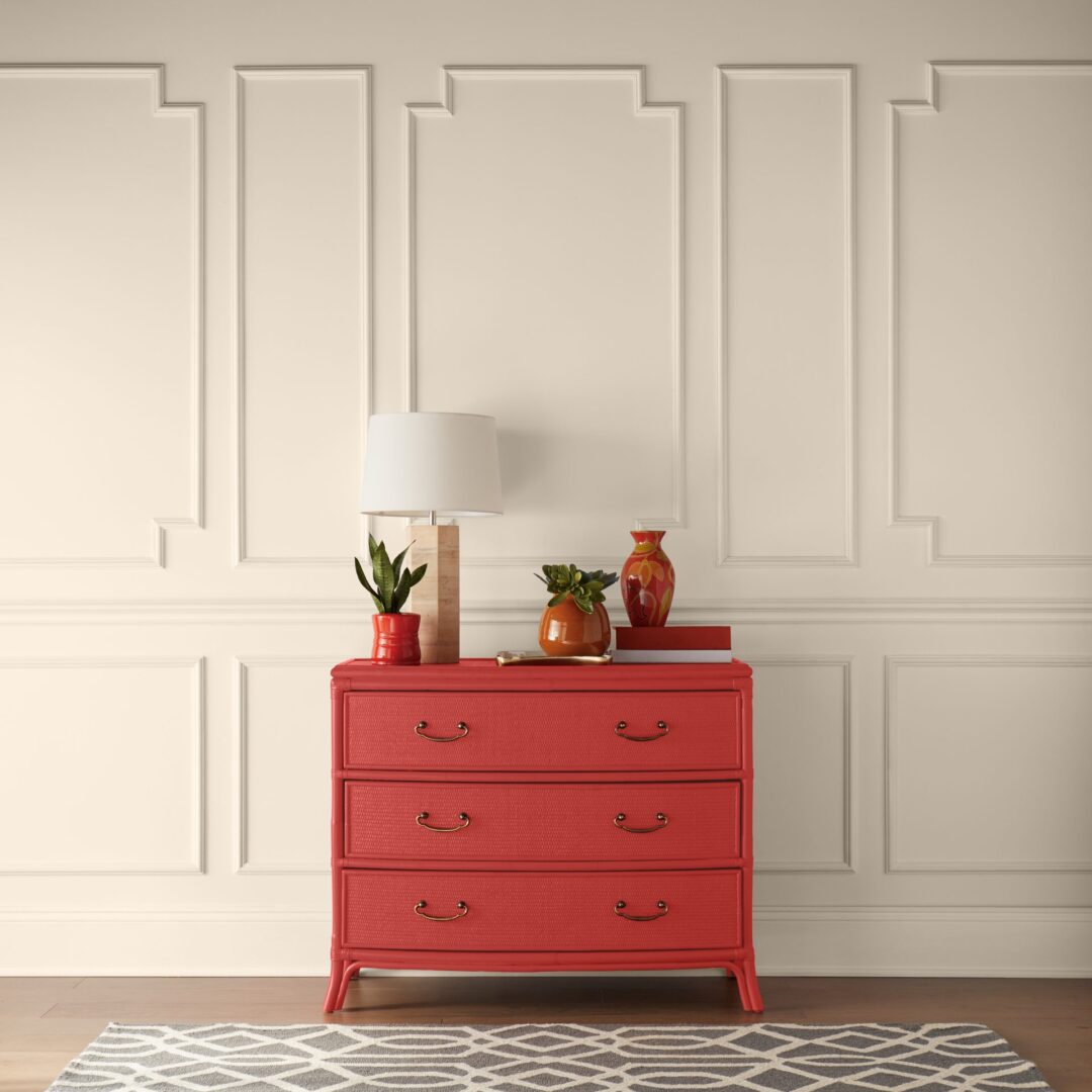 A red dresser sitting against a neutral wall.