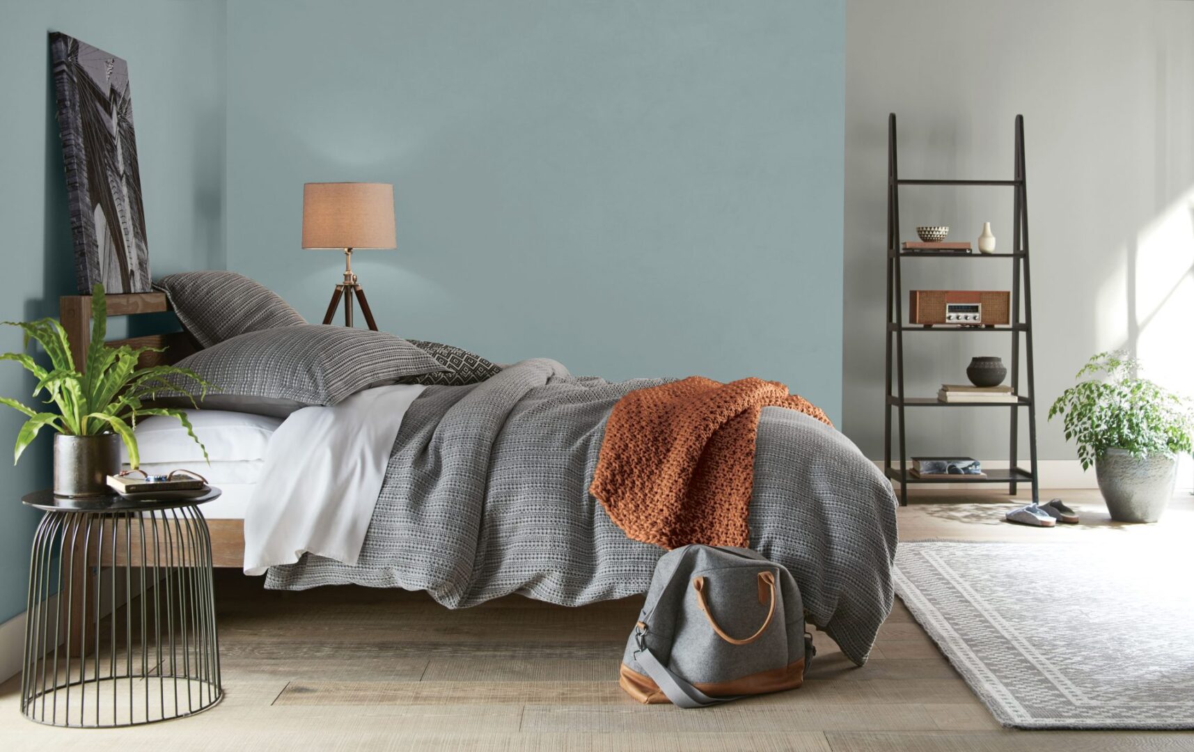 A bedroom with a calming blue hue painted on the walls.