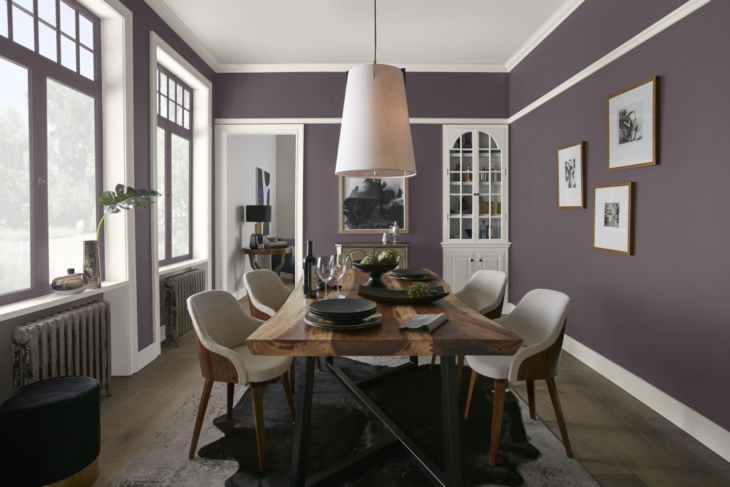A dining room with walls painted in a plum purple hue.