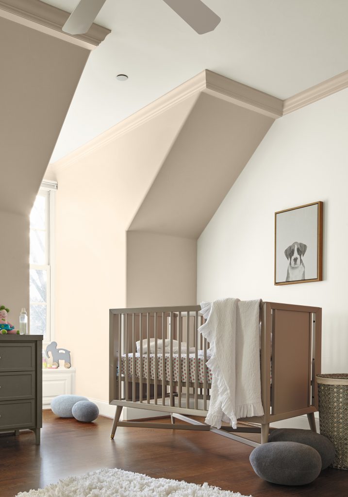 Nursery with soft beige walls, white crib and rug, wooden floor, and dog artwork above plush cushions.