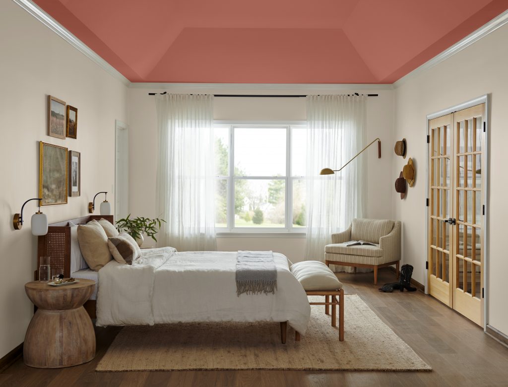 A bedroom with a recessed ceiling and a bed and a chair. 