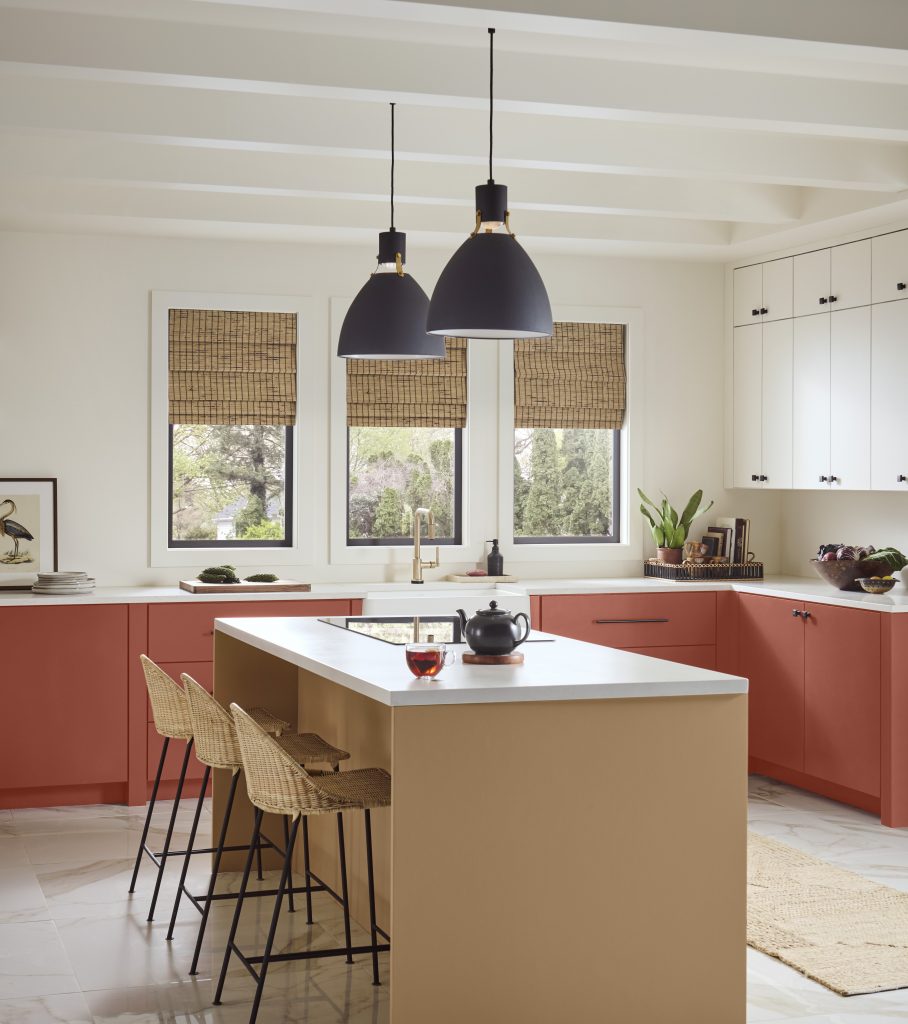 A kitchen with two-tone cabinets, island and chairs. 