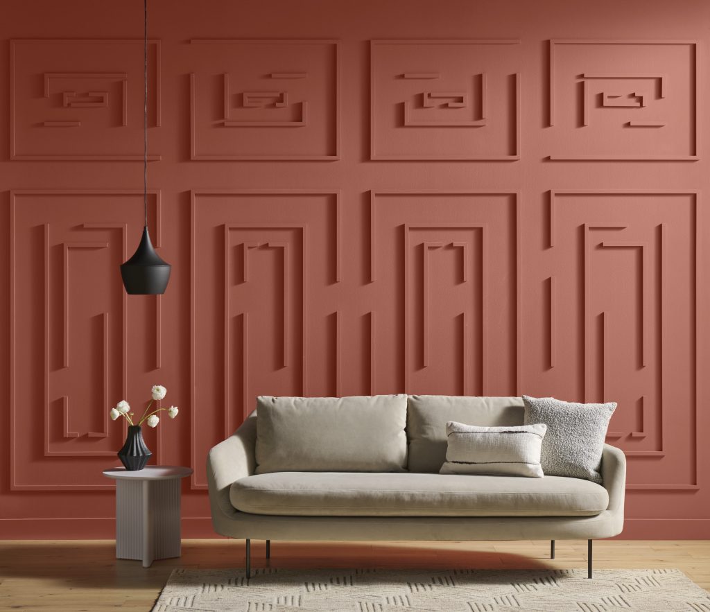 A couch in a room with paneled wall design that looks like a maze. 