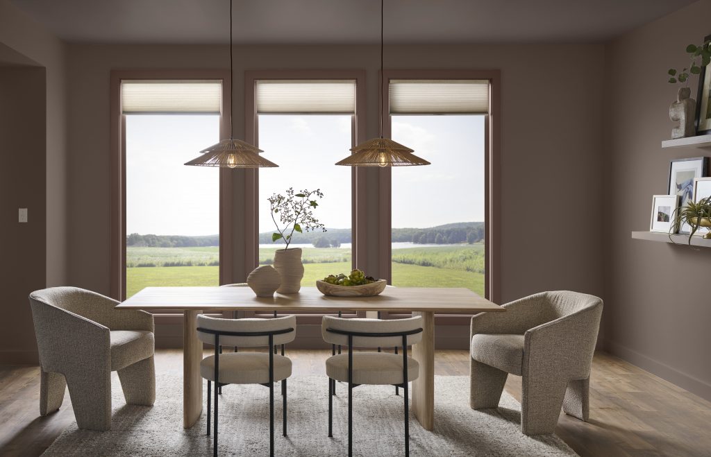 Dining room with wooden table, pendant lights, scenic window view, and decorative accents like a vase and bowl of décor.