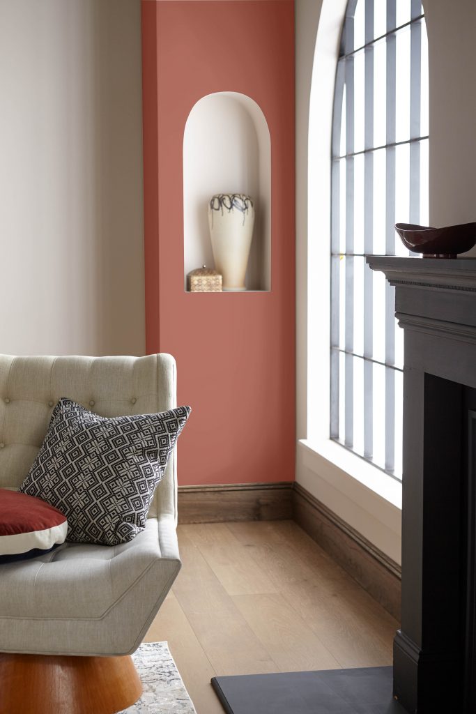 A living room with a fireplace and a red wall.