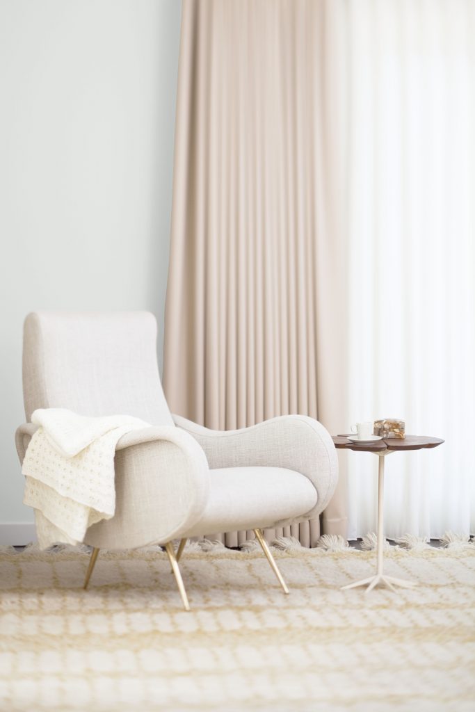 A cozy corner with the wall painted in a warm muted white.