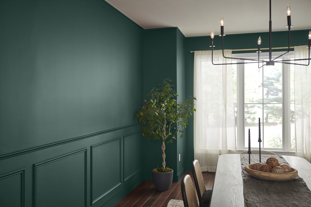 A dining room with a smoky jade hue painted on the walls.