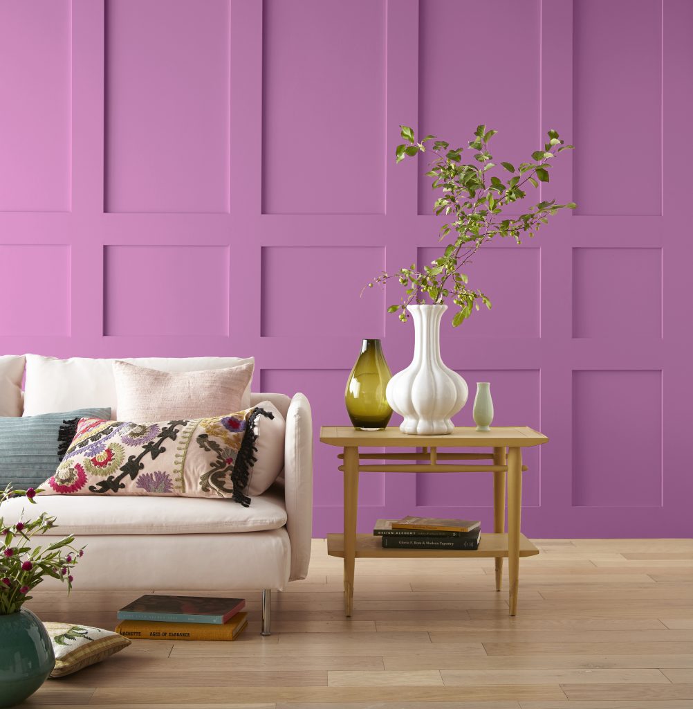 A living room with a bold magenta color painted on the walls.