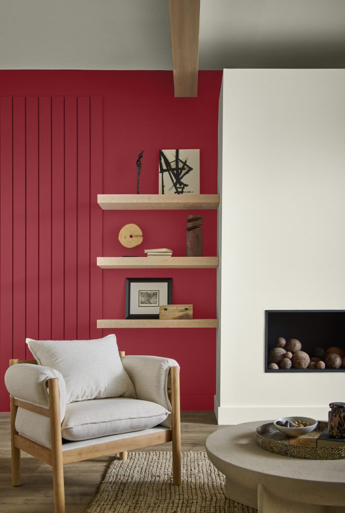 A living room with a fireplace in a soft white with surrounding wall in a warm red hue.