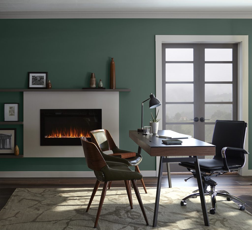 A cozy office with deep green painted walls.