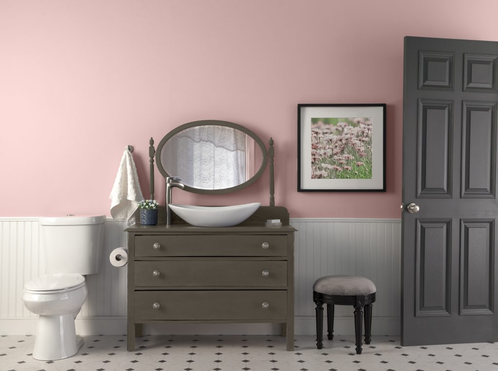 A bathroom that has a vintage feel with the walls in a pastel pink hue.