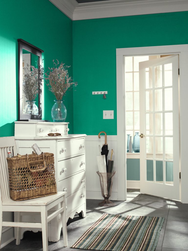 Entryway with rich jewel-tone green walls and bright white trim.