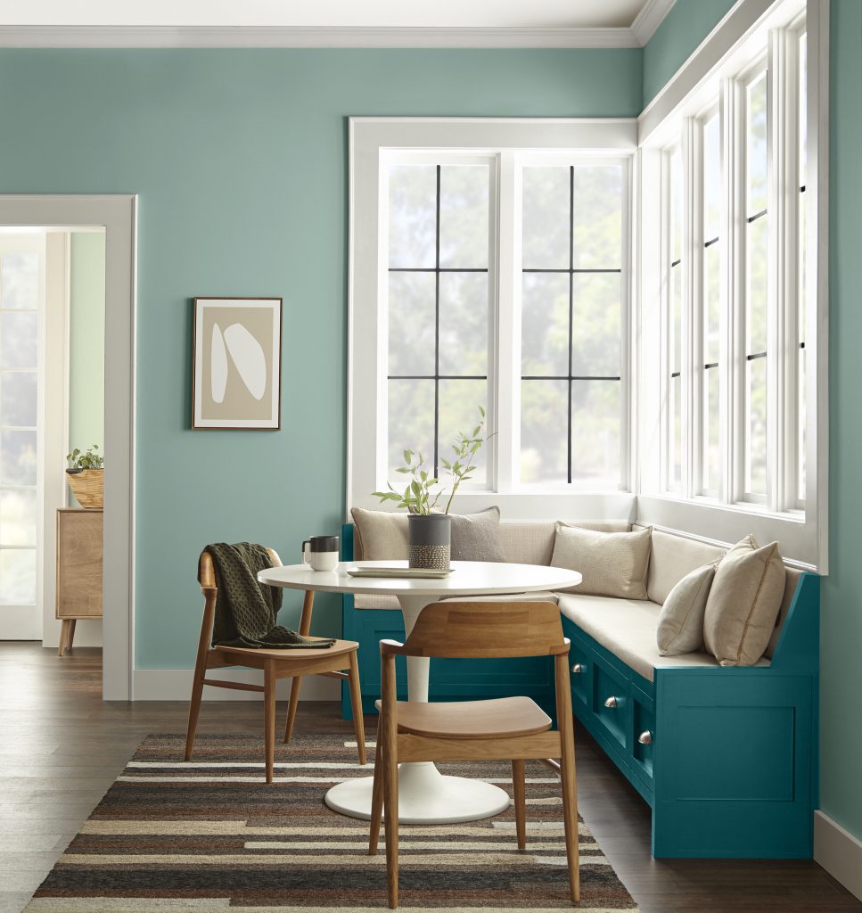 Cozy breakfast nook with soft green-blue walls and a deep blue bench.