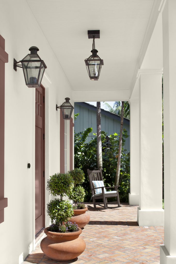 A deep brown rocking chair sits in a quiet corner beside warm-toned accents.