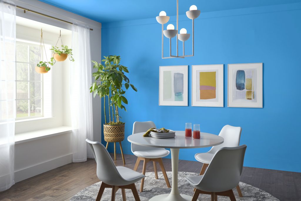 Dining room with light blue walls and ceiling surrounding a modern dining table.
