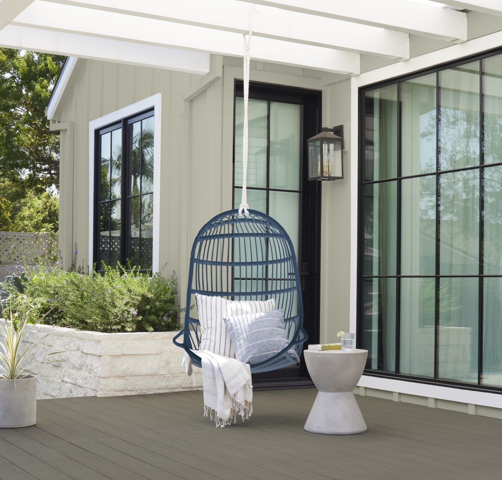 A dark navy swing chair contrasts with a soft green exterior.