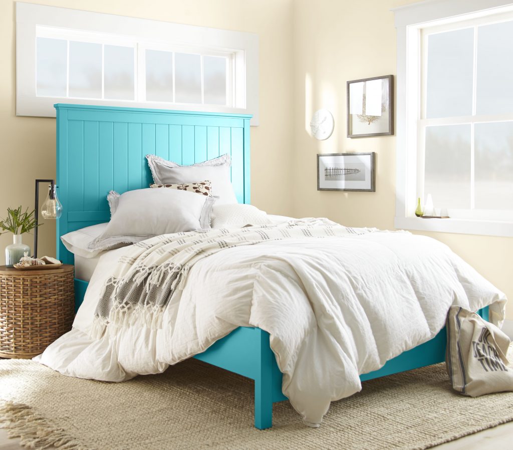 Bedroom with soft cream walls and a light blue headboard.
