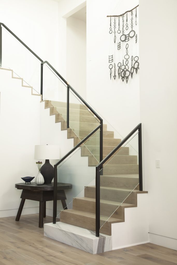 Bright stairway painted in warm off-white Twinkling Lights M280-1 with light wood steps and airy neutral styling.