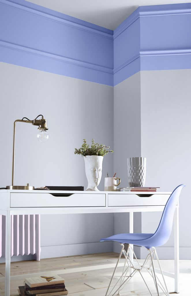 Creative desk nook with lavender-blue walls, white furniture and soft pastel accents.