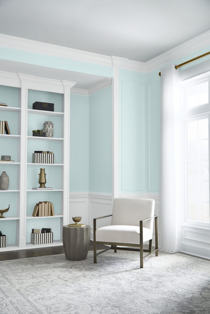 Light-filled living room with airy blue-green Helium M480-1 walls, built-ins and soft neutral furniture.