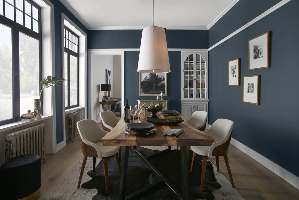 Dining room painted in Midnight Blue, white trim, and natural wood furniture.