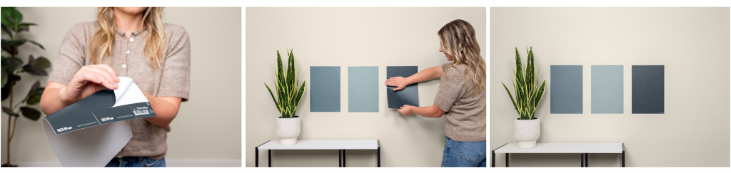 A person peels the backing from a Samplize peel-and-stick sample before applying it to a wall. A person applies three large paint sample stickers in blue tones to a wall to compare colors side by side. Three blue peelable paint color samples are displayed side by side on a wall near a potted plant for easy color comparison.