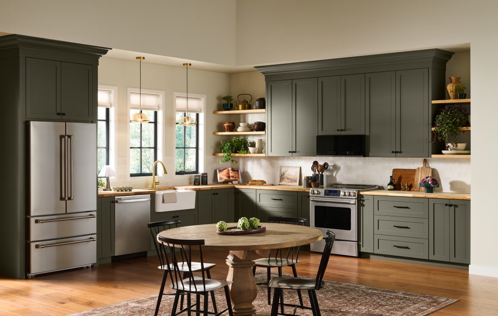 A welcoming kitchen with cabinets painted in BEHR Grounded, featuring warm wood countertops, open shelving, stainless steel appliances, and a round dining table.