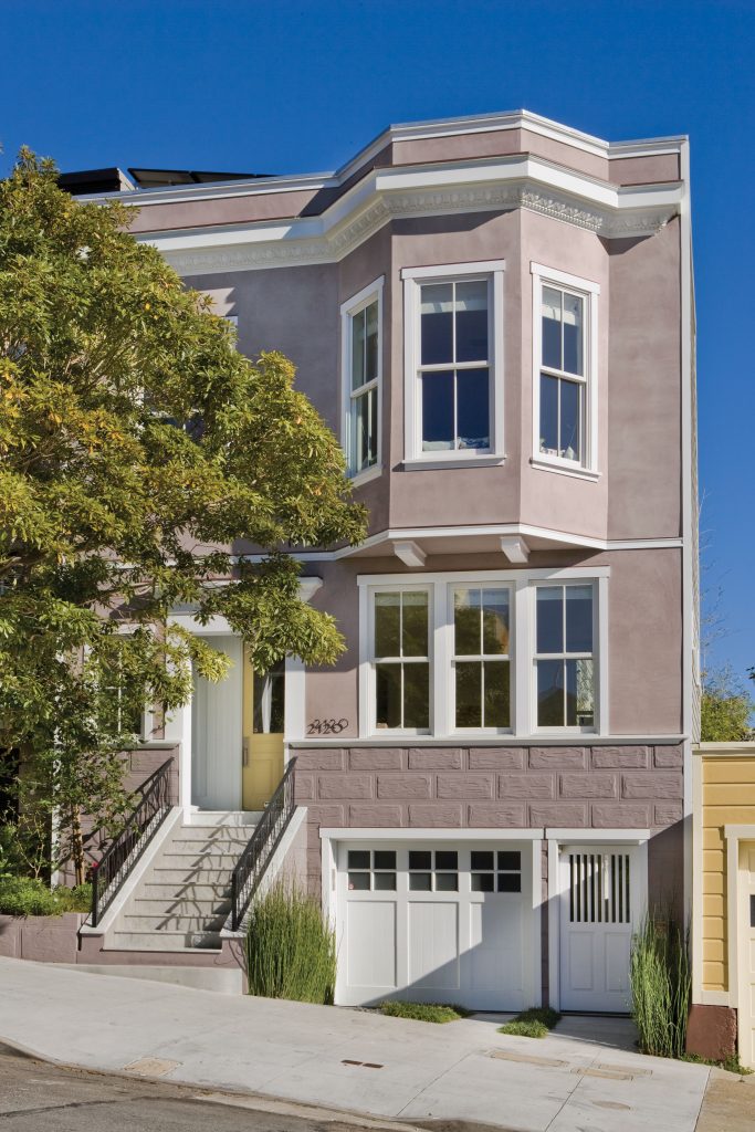 Exterior home painted in Vintage Tea Rose with Cameo White trim, white-framed windows, and classic architectural details for a romantic Regency-inspired exterior color palette.