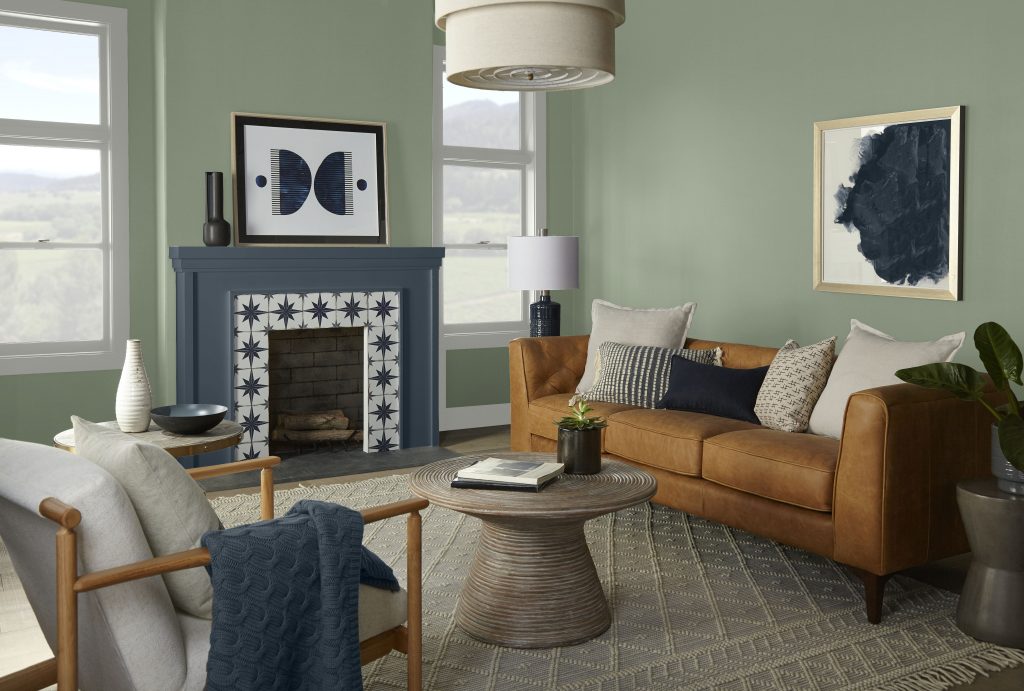 Living room with BEHR Bitter Sage N390-4 walls, a Midnight Blue N480-7 fireplace surround and a tan leather sofa.