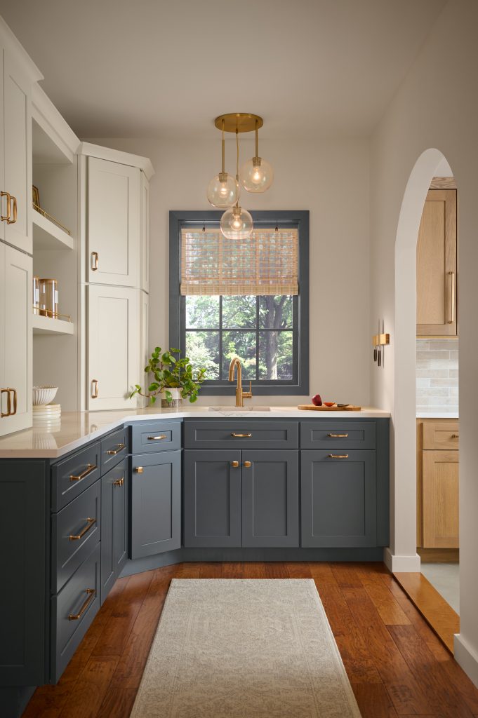 Kitchen with Nightfall T27-04 lower cabinets, Wheat Bread neutral walls, Blank Canvas upper cabinets, warm wood flooring, and brass hardware.