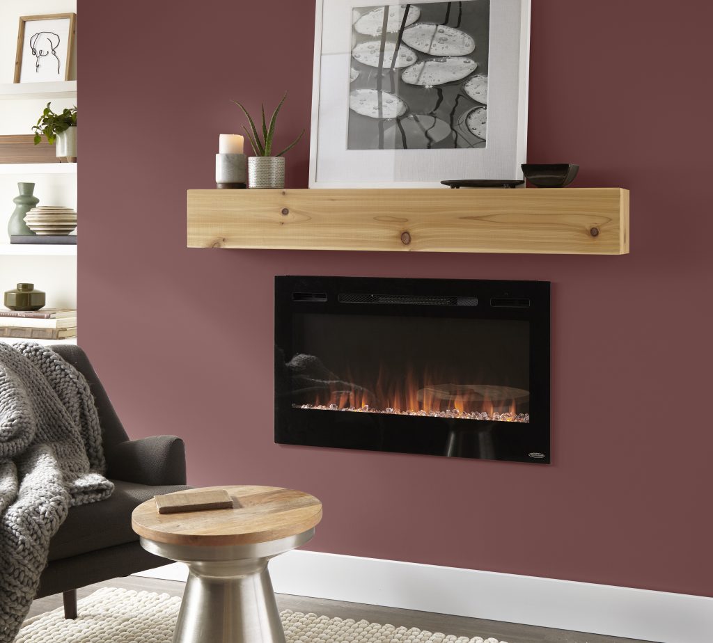 Fireplace wall painted Twinberry MQ1-14, paired with a natural wood mantel, black fireplace, neutral furnishings, greenery and soft gray textiles.