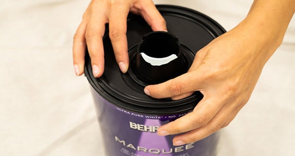 Person removing the simple pour lid spout by turning it counter-clockwise