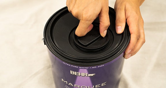 Person removing the simple pour lid cap by turning it counter-clockwise
