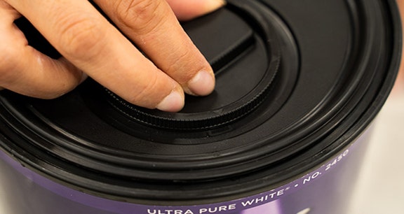 Person securing the simple pour lid cap by turning it clockwise