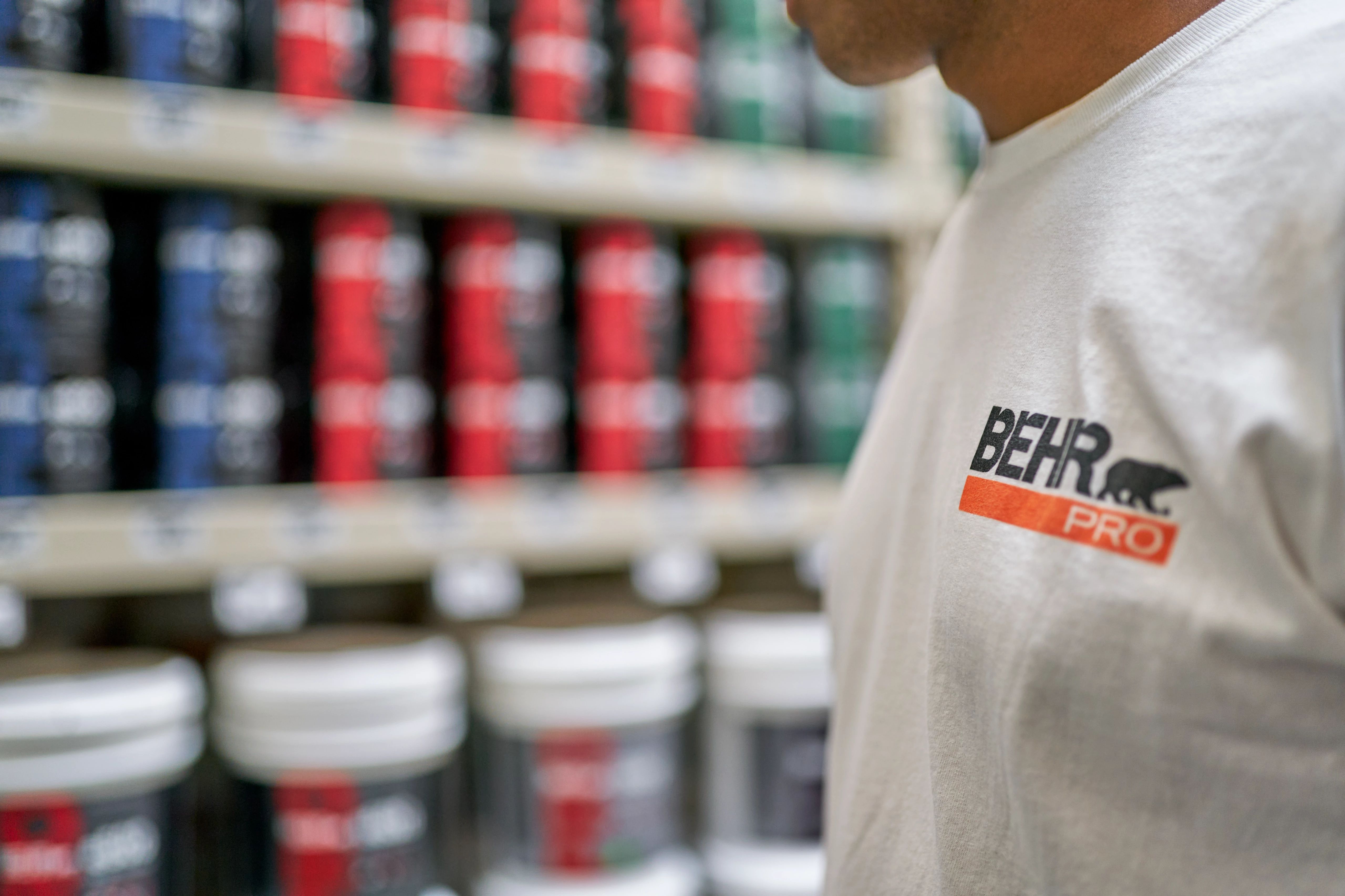 Behr Pro Painter looking at 5 gallon BEHR paint buckets